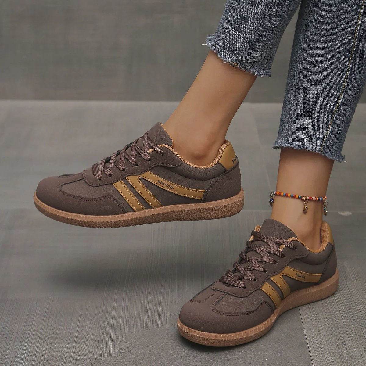 Pair of off-white Elara orthopaedic cushioned trainers displayed on a clean surface, emphasizing their modern aesthetic.