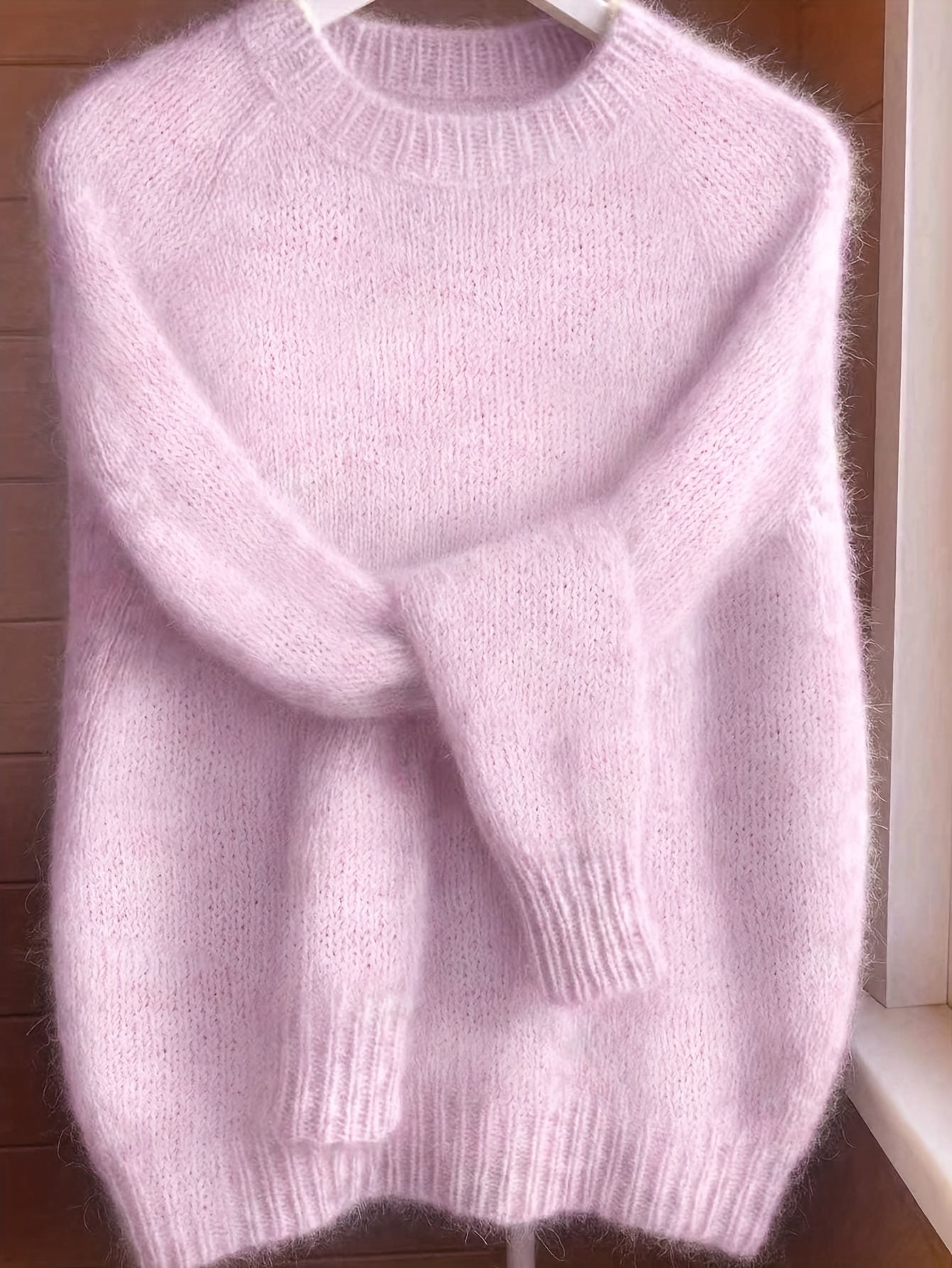 A stack of folded Elara cashmere-blend sweaters in various colors, emphasizing the quality and rich palette.