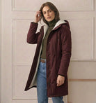 Back view of the Elara parka, showing the deep, fixed storm hood and overall elegant drape.