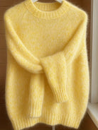 Detail shot of the crew neck and shoulder seam of the orange Elara cashmere-blend sweater, focusing on craftsmanship.