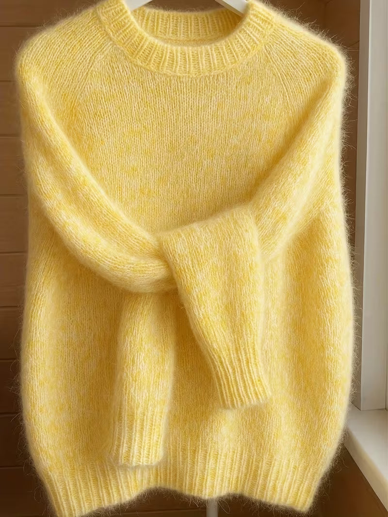 Detail shot of the crew neck and shoulder seam of the orange Elara cashmere-blend sweater, focusing on craftsmanship.
