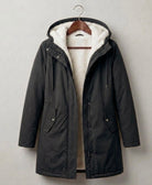 Close-up on the functional storm hood of the Elara parka, designed for comprehensive face and hair protection.