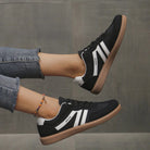 Angled shot of the black Elara orthopaedic cushioned trainer, showcasing its contrast sole and secure lacing system.