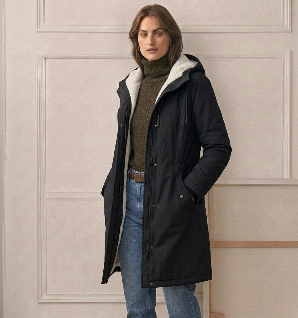 A model zipping up the Elara parka, illustrating the smooth operation of the wind-blocking closure.