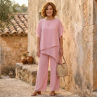 Model in a burgundy blouse interacting in a light-filled setting, perfect for an elegant social gathering.