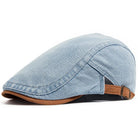 Side profile of the denim flat cap, highlighting the curved brim and tailored construction.
