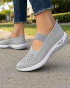 Grey Carry slip-ons worn while walking, flexible cushioned sole mid-step