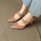 Detailed shot of the gold-tone buckle on the adjustable strap of a leather slingback heel.
