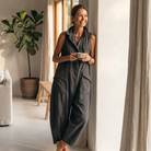 Side profile of the khaki sleeveless jumpsuit, highlighting the dropped crotch and rolled ankle cuff.