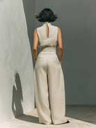Lifestyle shot of a model wearing the light blue wide-leg trousers, demonstrating ease of movement.