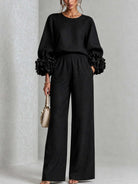 Detailed fabric texture of pink wide-leg trousers, showing the quality and soft feel of the material.