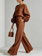 Outfit pairing suggestion with black wide-leg trousers, styled for a chic evening gathering.