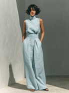 Model sitting comfortably in the beige wide-leg trousers, demonstrating flexibility and all-day wearability.