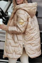 Model wearing a beige Kiera hooded winter jacket in an outdoor setting.