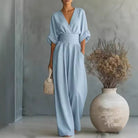 Side profile of a model in a light blue wide-leg jumpsuit, showcasing the comfortable fit and flowing fabric.
