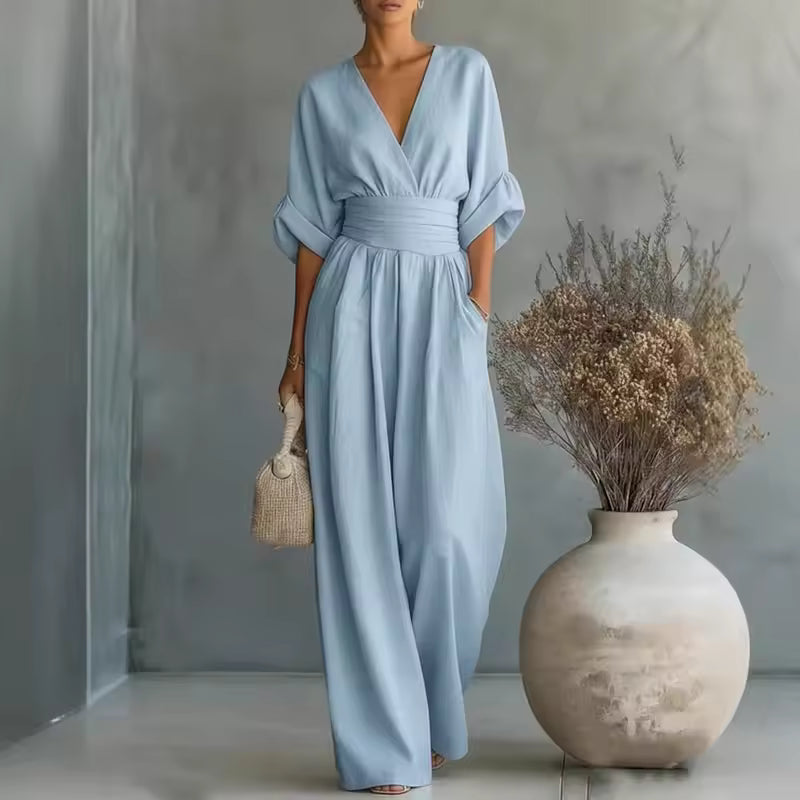 Side profile of a model in a light blue wide-leg jumpsuit, showcasing the comfortable fit and flowing fabric.