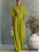 A model demonstrating the flattering high-waisted and wide-leg design of the green jumpsuit in motion.