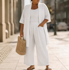 Side profile of a model wearing the Lila relaxed three-piece set in blue, illustrating the flowing silhouette of the wide-leg trousers.