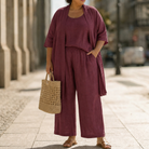 Lifestyle shot of a woman wearing the Lila relaxed three-piece set in black, styled with accessories for a chic urban look.
