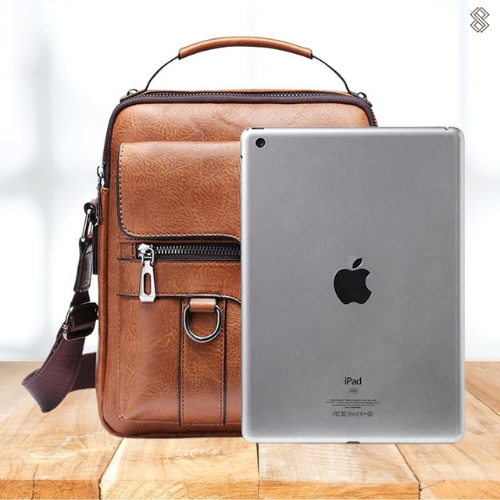 Overhead shot of the Caleb shoulder bag with daily items neatly arranged inside, showcasing its capacity.
