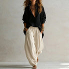 A woman walking in stylish cream wide-leg trousers, demonstrating their easy movement and graceful drape.