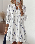 Front view of the Kira striped A-line dress in white, showcasing its wavy pattern and lapel collar.