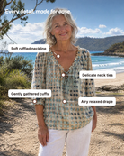 Black Xylia blouse worn by a model in a café setting, suitable for brunch or a casual meeting.