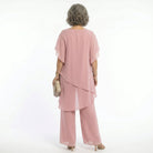 Close-up on the fabric texture and color vibrancy of the blush pink blouse, suggesting soft comfort.