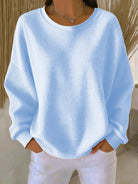 Front view of the Odette knit sweater in sky blue, showcasing its loose fit and textured knit.