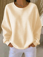 Model from behind in the Odette knit sweater in apricot, demonstrating its comfortable fit.