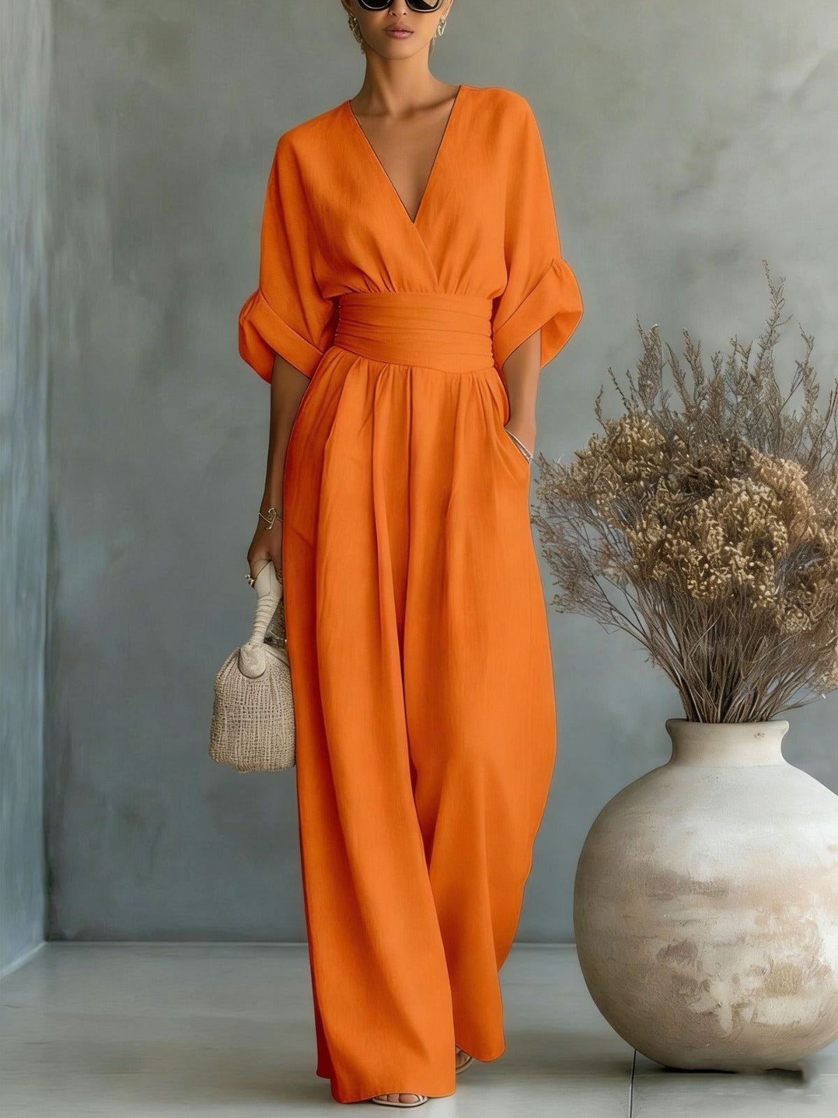 Close-up detail of the sophisticated V-neckline and soft texture of the white elegant jumpsuit.