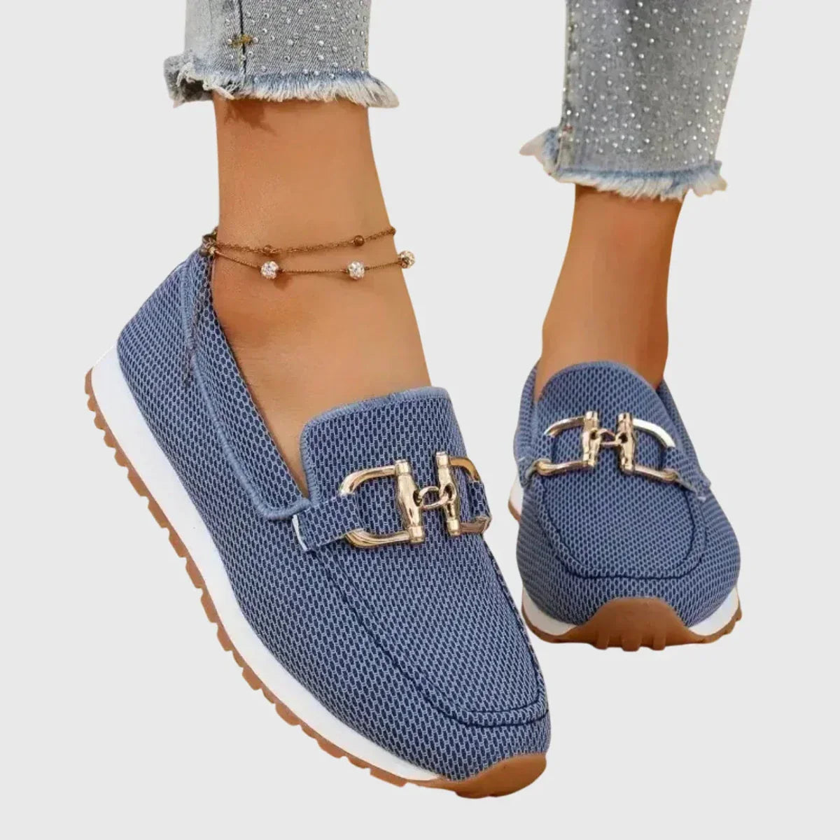 Close-up of the gold clasp detail on blue orthopedic pants, emphasizing the sporty elegance.