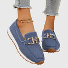 Close-up of the gold clasp detail on blue orthopedic pants, emphasizing the sporty elegance.