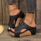 Front view of Solange studded wedge sandals in black, showcasing the metallic detailing and heel height.