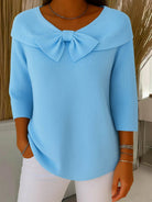 Front view of the Soraya relaxed knit tunic in a soft blue color, showcasing its loose fit and rounded neckline with decorative ties.