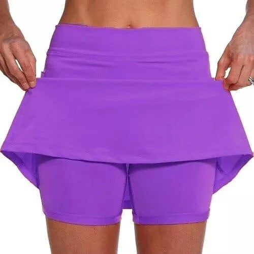 Model in a light gray skort performing an exercise, showcasing the freedom of movement it provides.