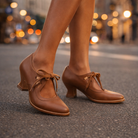 Frontal view of Talia elegant leather lace heels in brown, emphasizing their sleek silhouette.
