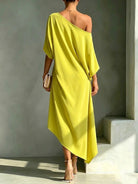 Side profile of the Lana asymmetrical midi dress in a serene light blue, revealing the flattering cut and contemporary style.